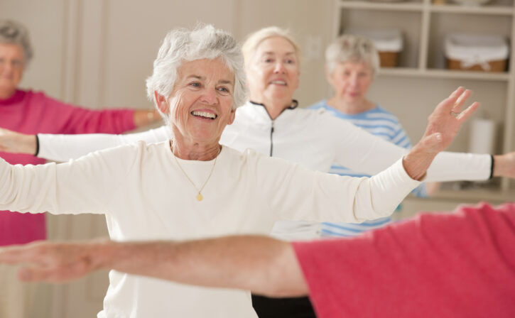 Seniors doing arm strengthening exercises in a health club